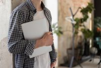 Suasana santai seorang pekerja yang mematikan laptop setelah menyelesaikan tenggat waktu kerja untuk menikmati momen istirahat sore di rumah.