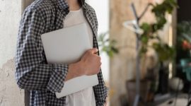 Suasana santai seorang pekerja yang mematikan laptop setelah menyelesaikan tenggat waktu kerja untuk menikmati momen istirahat sore di rumah.
